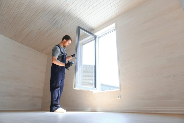 A worker installs windows in a new modular home. The concept of a new home